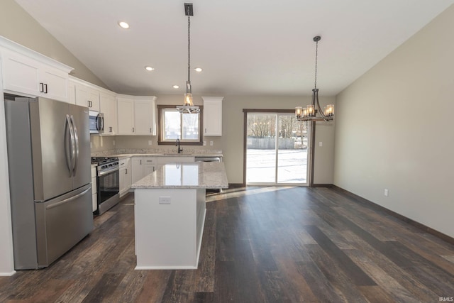 kitchen with white cabinetry, stainless steel appliances, a center island, and hanging light fixtures