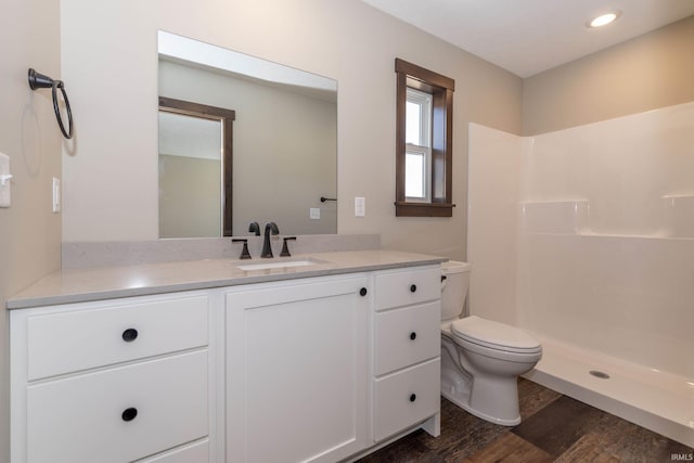 bathroom with vanity, a shower, wood-type flooring, and toilet