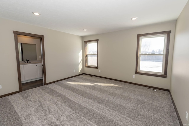 spare room featuring sink and carpet flooring