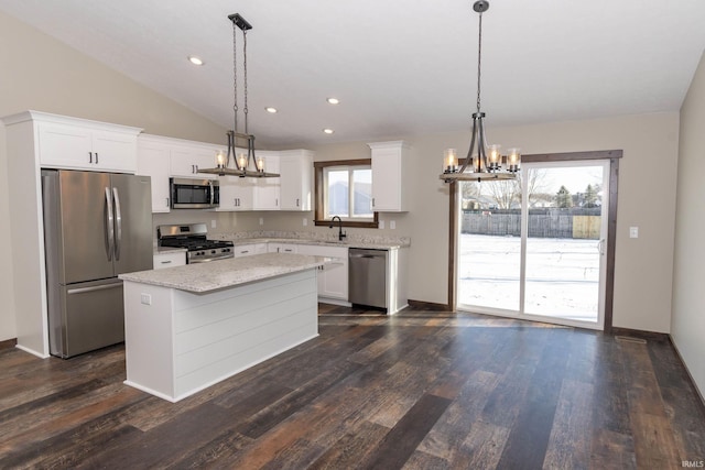 kitchen featuring stainless steel appliances, decorative light fixtures, a kitchen island, and white cabinets