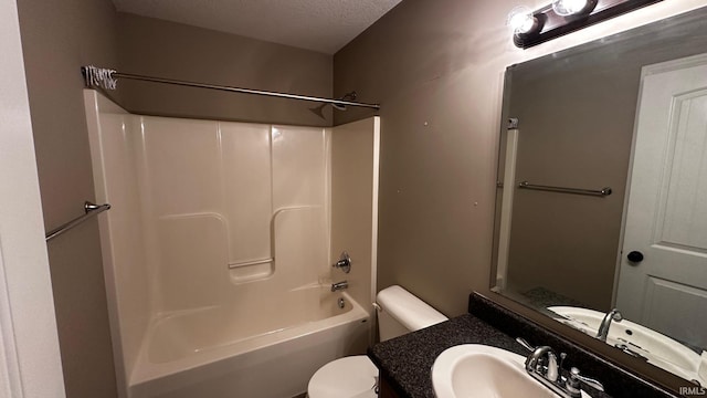 full bathroom featuring shower / bathing tub combination, toilet, sink, and a textured ceiling