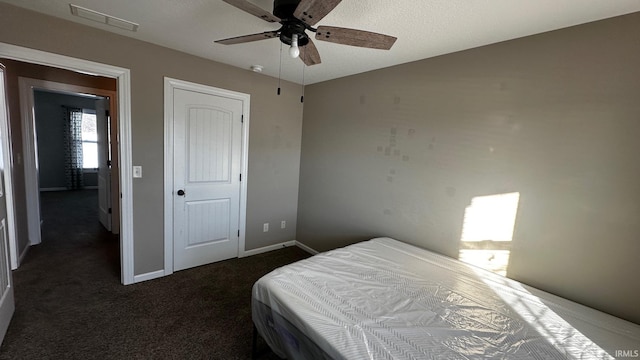 bedroom with ceiling fan and dark carpet