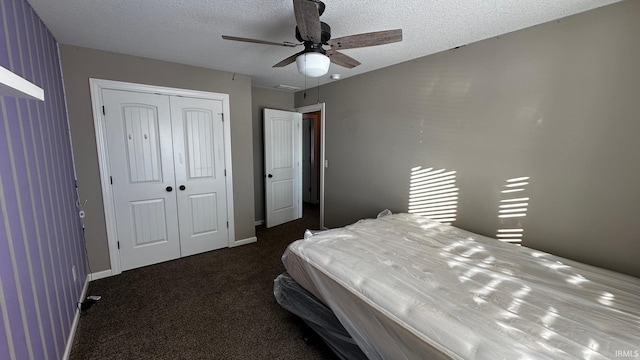 carpeted bedroom featuring a textured ceiling, a closet, and ceiling fan