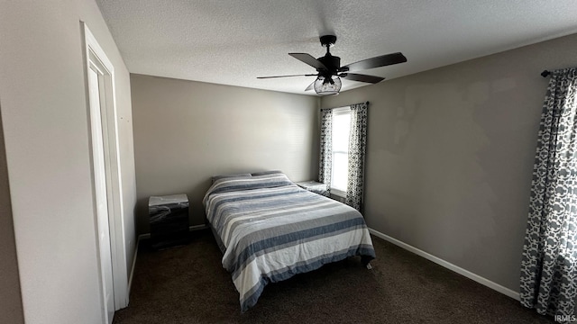 carpeted bedroom featuring ceiling fan and a textured ceiling