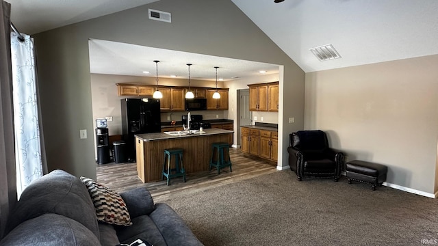 carpeted living room with sink and high vaulted ceiling