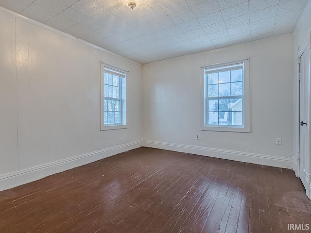 unfurnished room featuring dark wood-type flooring and ornamental molding