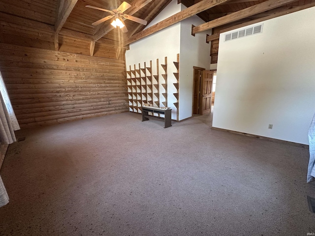 spare room with beamed ceiling, ceiling fan, wood ceiling, and rustic walls