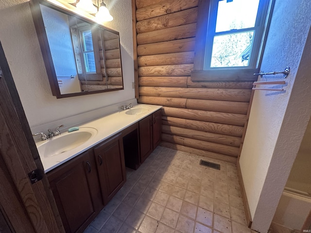 bathroom featuring rustic walls and vanity