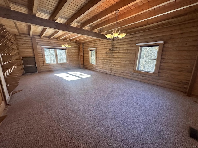 unfurnished room with rustic walls, wood ceiling, beam ceiling, a chandelier, and plenty of natural light