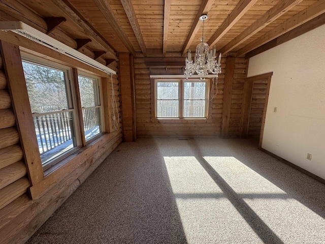 empty room featuring beam ceiling, wooden ceiling, a healthy amount of sunlight, and a notable chandelier