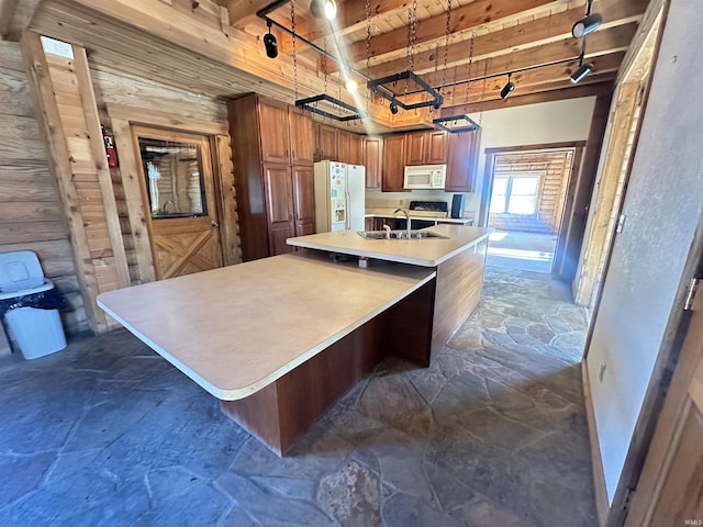 kitchen featuring beamed ceiling, a center island with sink, white appliances, and wood ceiling