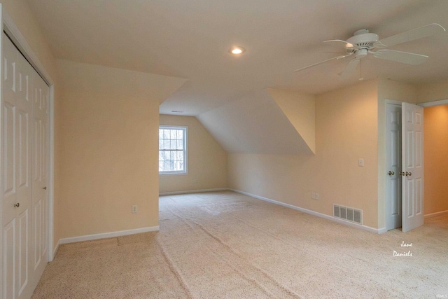 additional living space with lofted ceiling, light carpet, and ceiling fan