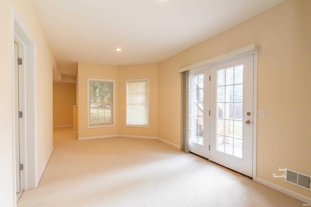 doorway to outside with light colored carpet