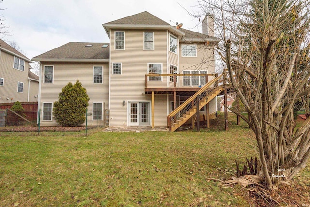 back of house featuring a deck and a lawn