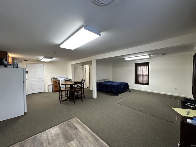 bedroom with white fridge and dark colored carpet