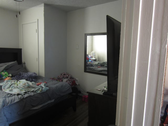 bedroom with hardwood / wood-style floors and a textured ceiling