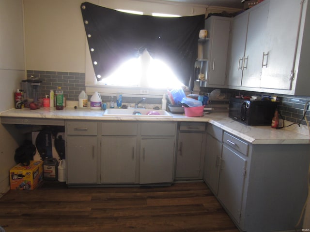 kitchen with decorative backsplash, dark wood-type flooring, and sink