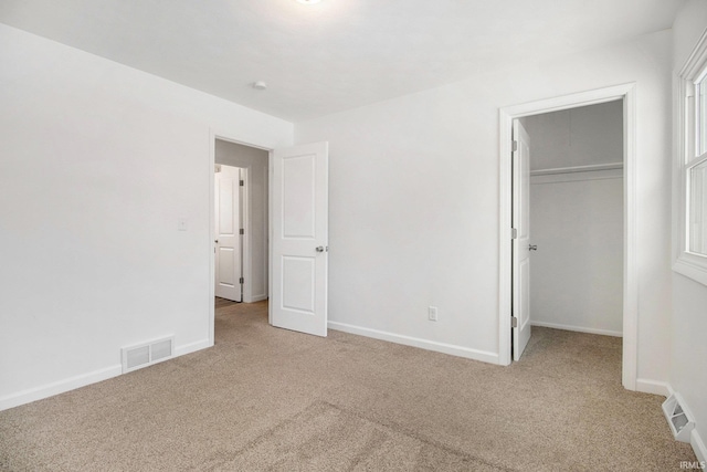 unfurnished bedroom featuring light colored carpet and a closet