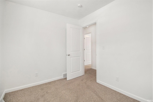 unfurnished room featuring light carpet