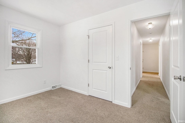 unfurnished room featuring light carpet