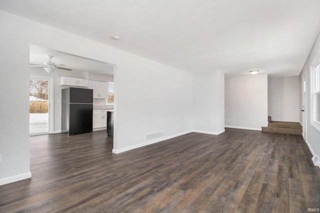 unfurnished living room featuring ceiling fan and dark hardwood / wood-style flooring