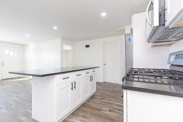 kitchen featuring white cabinets, dark hardwood / wood-style floors, a center island, and stainless steel appliances