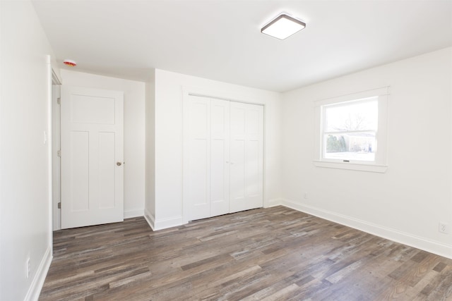 unfurnished bedroom featuring dark wood-type flooring and a closet