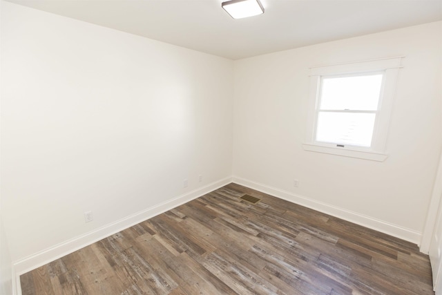 spare room featuring dark wood-type flooring