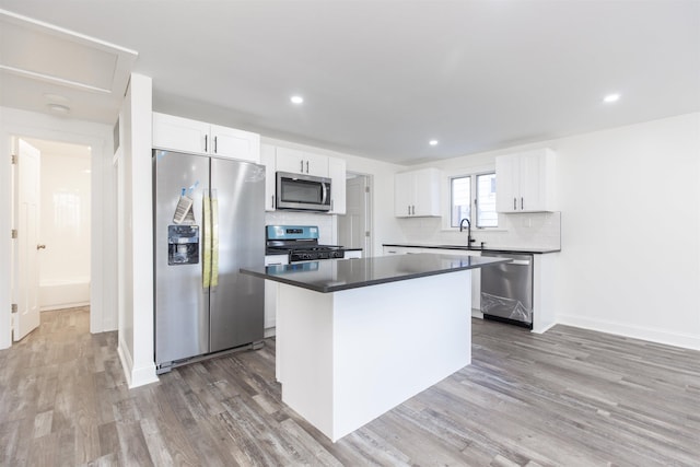 kitchen featuring decorative backsplash, a kitchen island, white cabinetry, and appliances with stainless steel finishes