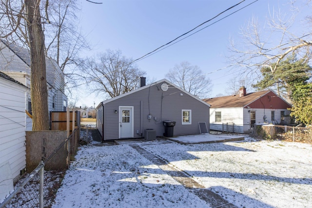 snow covered rear of property featuring cooling unit