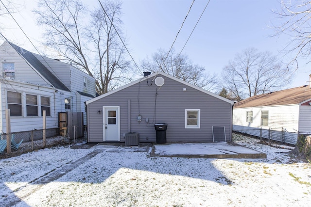 snow covered house with central AC unit