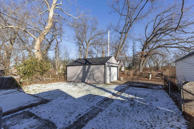 yard covered in snow with an outdoor structure and a garage