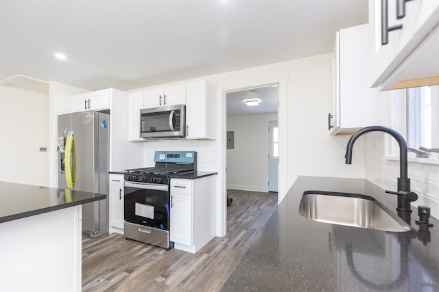 kitchen featuring sink, dark wood-type flooring, decorative backsplash, white cabinets, and appliances with stainless steel finishes