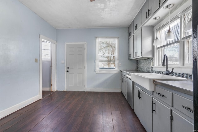 kitchen with pendant lighting, decorative backsplash, dark hardwood / wood-style flooring, and sink