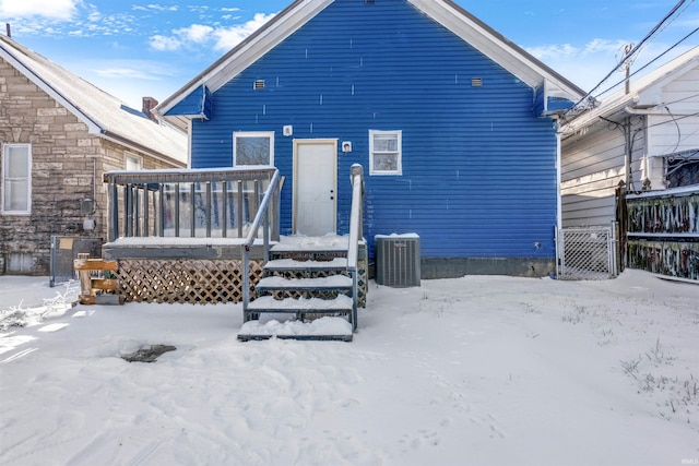 snow covered property featuring central AC unit