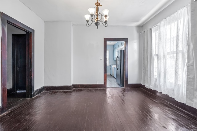 unfurnished room with dark hardwood / wood-style flooring and a chandelier