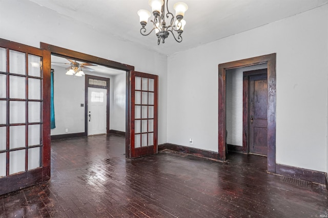 spare room with french doors, dark wood-type flooring, and ceiling fan with notable chandelier