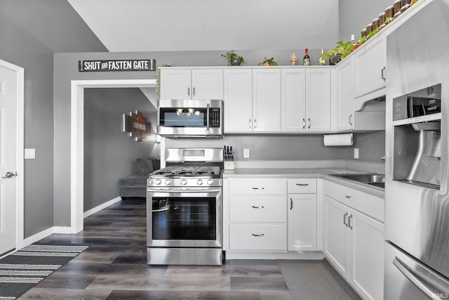 kitchen featuring stainless steel appliances, white cabinetry, dark hardwood / wood-style floors, and sink