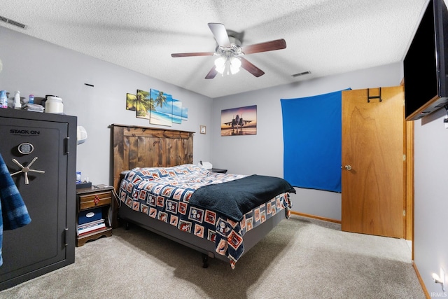 carpeted bedroom with ceiling fan and a textured ceiling