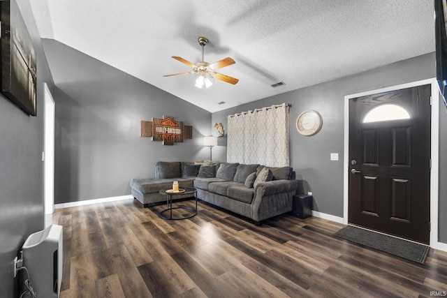 living room with a textured ceiling, dark hardwood / wood-style floors, and vaulted ceiling