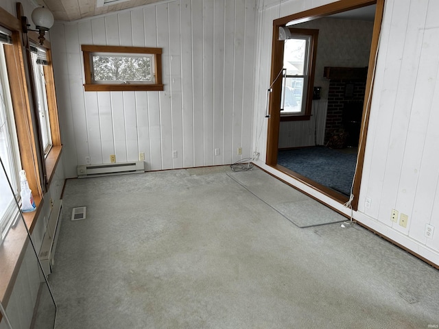 spare room with plenty of natural light, a baseboard radiator, and a brick fireplace