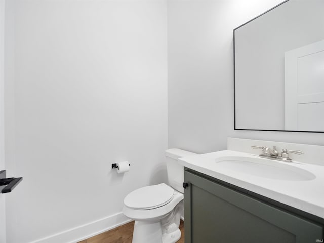 bathroom featuring vanity, hardwood / wood-style flooring, and toilet