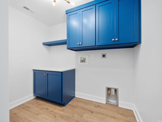 washroom with electric dryer hookup, cabinets, light wood-type flooring, and hookup for a washing machine