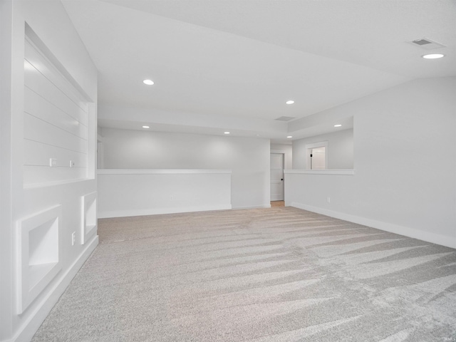 empty room with light colored carpet and vaulted ceiling