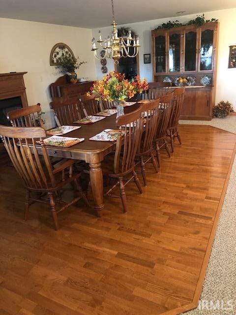 dining space with hardwood / wood-style flooring and a notable chandelier