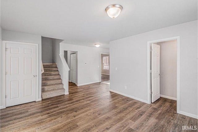 empty room featuring stairway, baseboards, and wood finished floors