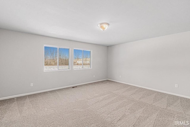 carpeted spare room featuring baseboards