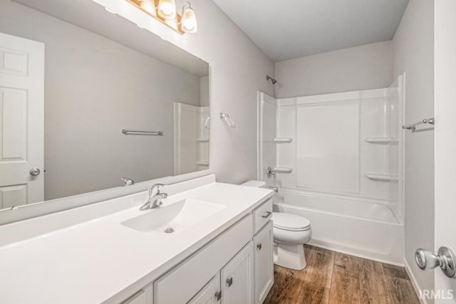 full bath featuring tub / shower combination, vanity, toilet, and wood finished floors