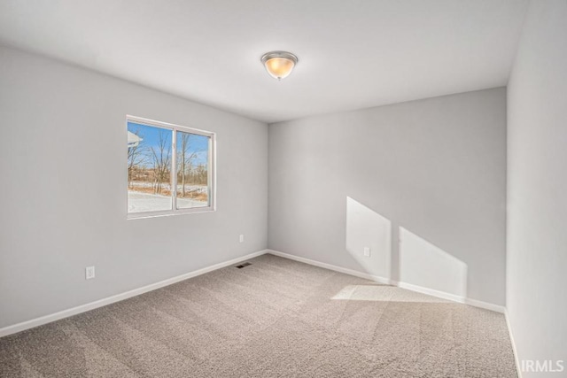 spare room with baseboards, visible vents, and carpet flooring