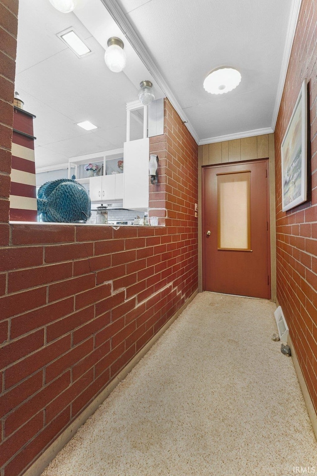 hallway featuring brick wall and ornamental molding